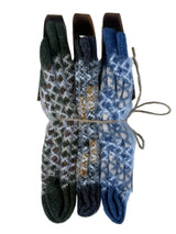 Three pairs of folded knit gloves bundled together with twine, displayed against a white background. The gloves feature intricate Fair Isle patterns in dark green, charcoal gray, and slate blue.